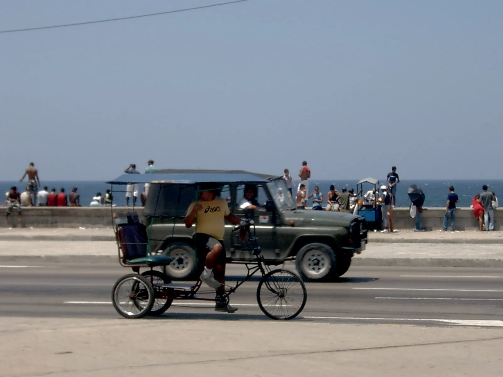 A bicitaxi riding along the Malecón